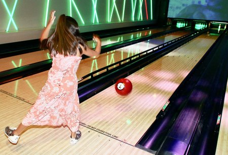 A youngster takes a stab at bowling in the Coyote Entertainment Center.